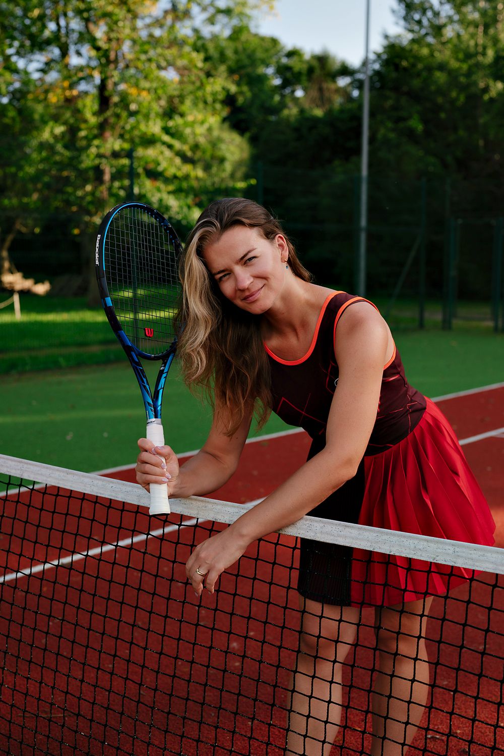 Ilona leaning on the net, smiling