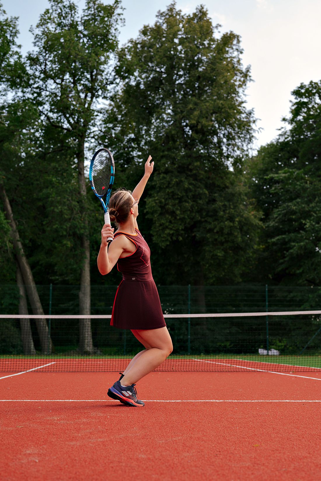 Ilona Schorm serving on a clay court